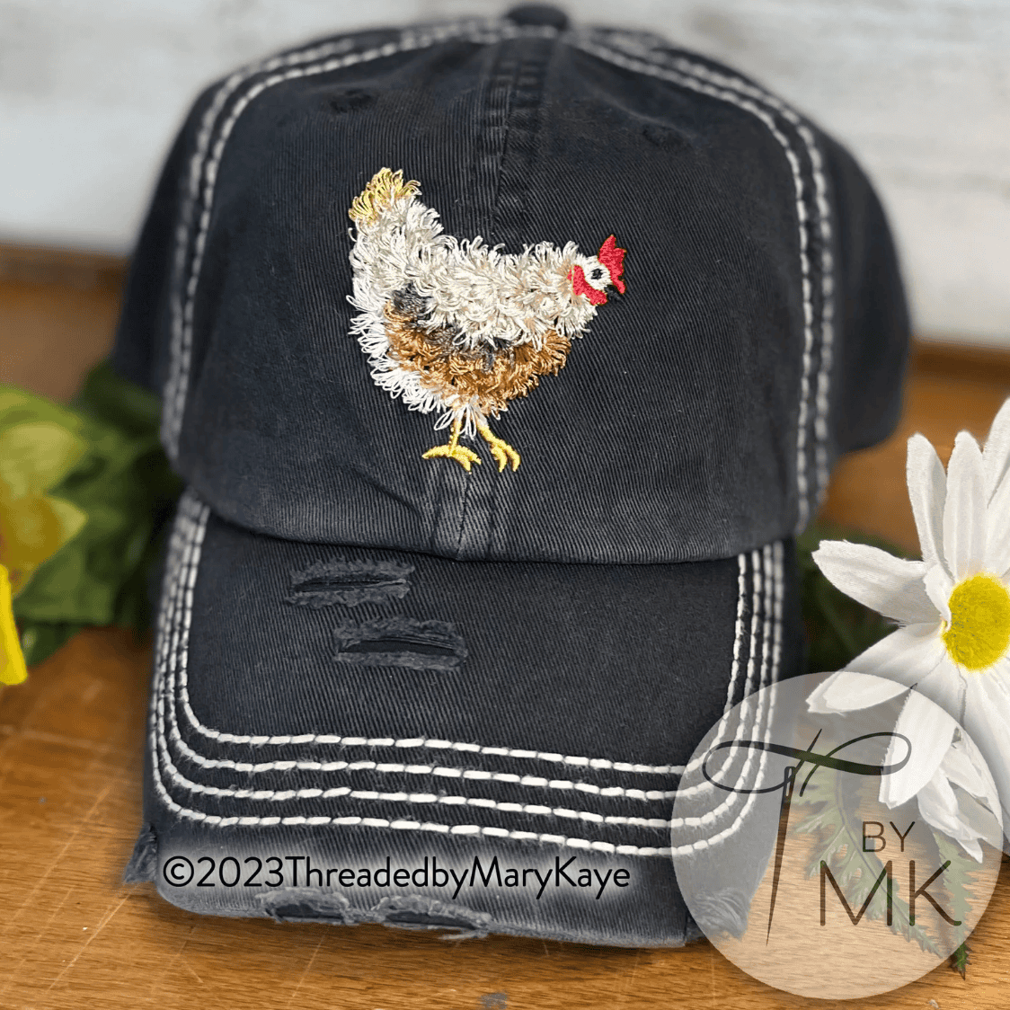 a black hat with a fringed chicken embroidered on the front